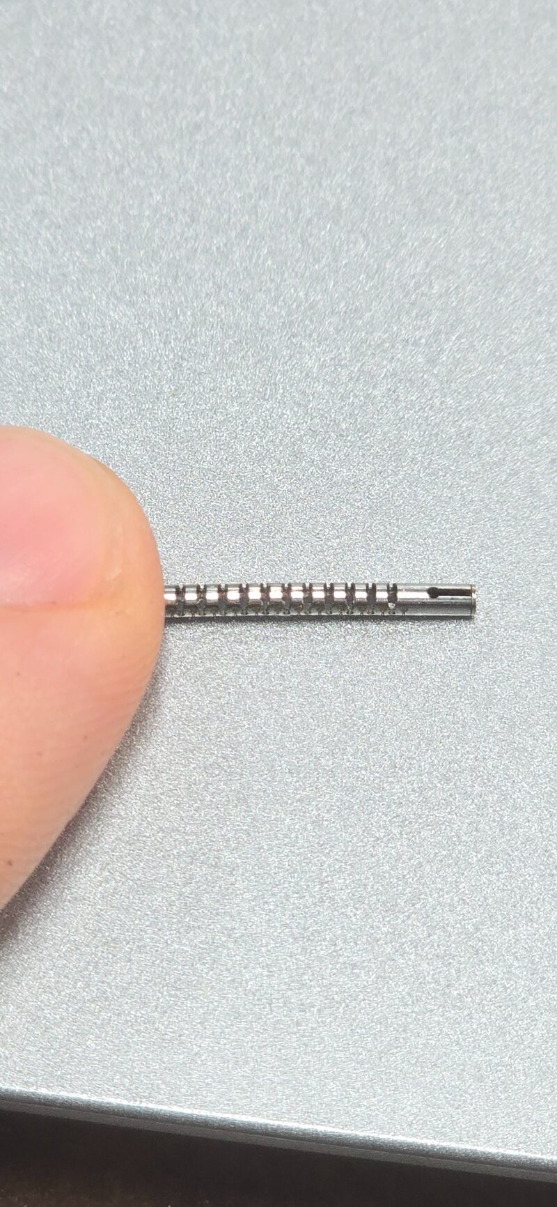 Laser-cut medical tube — fingertip scale reference